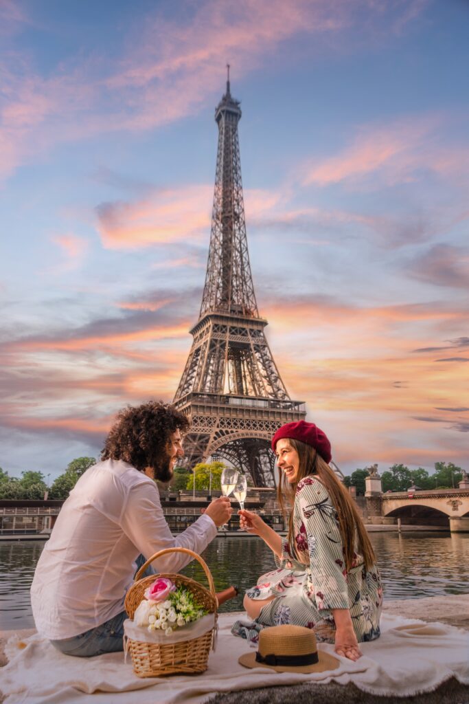 Couple heureux faisant un pique nique devant la tour Eiffel au bord de la Seine à Paris